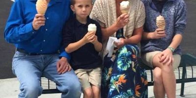 This woman offered to take a picture of a family that seemed very happy that they went for ice cream together